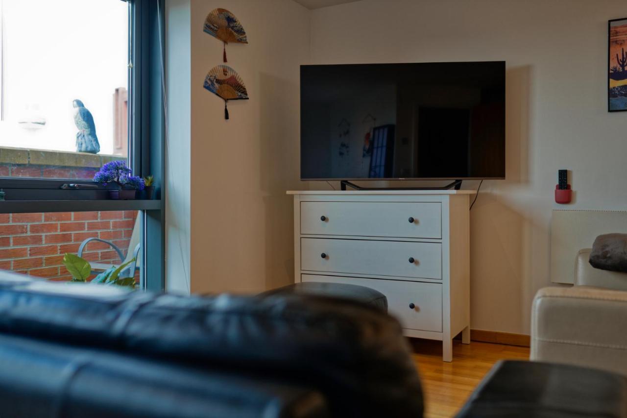 A living room with a sofa, television and dresser in the Liverpool city centre apartment